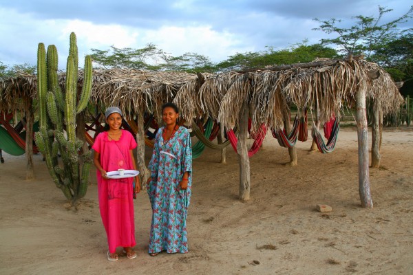 Wayúu women in front of traditional rancheria. Photo courtesy Theculturetrip.com/ Photograph by Tanenhaus. 