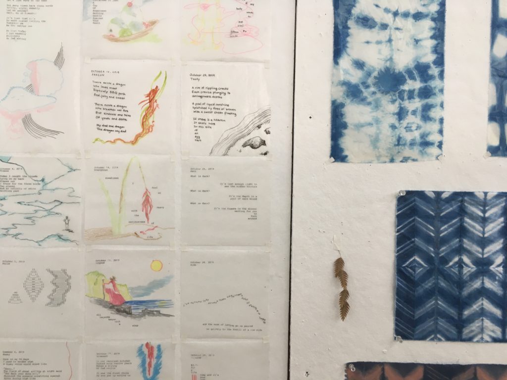 Close-up image of Yidan's work space at TAC; swatches of fabric, small poems and sketches tacked to the wall